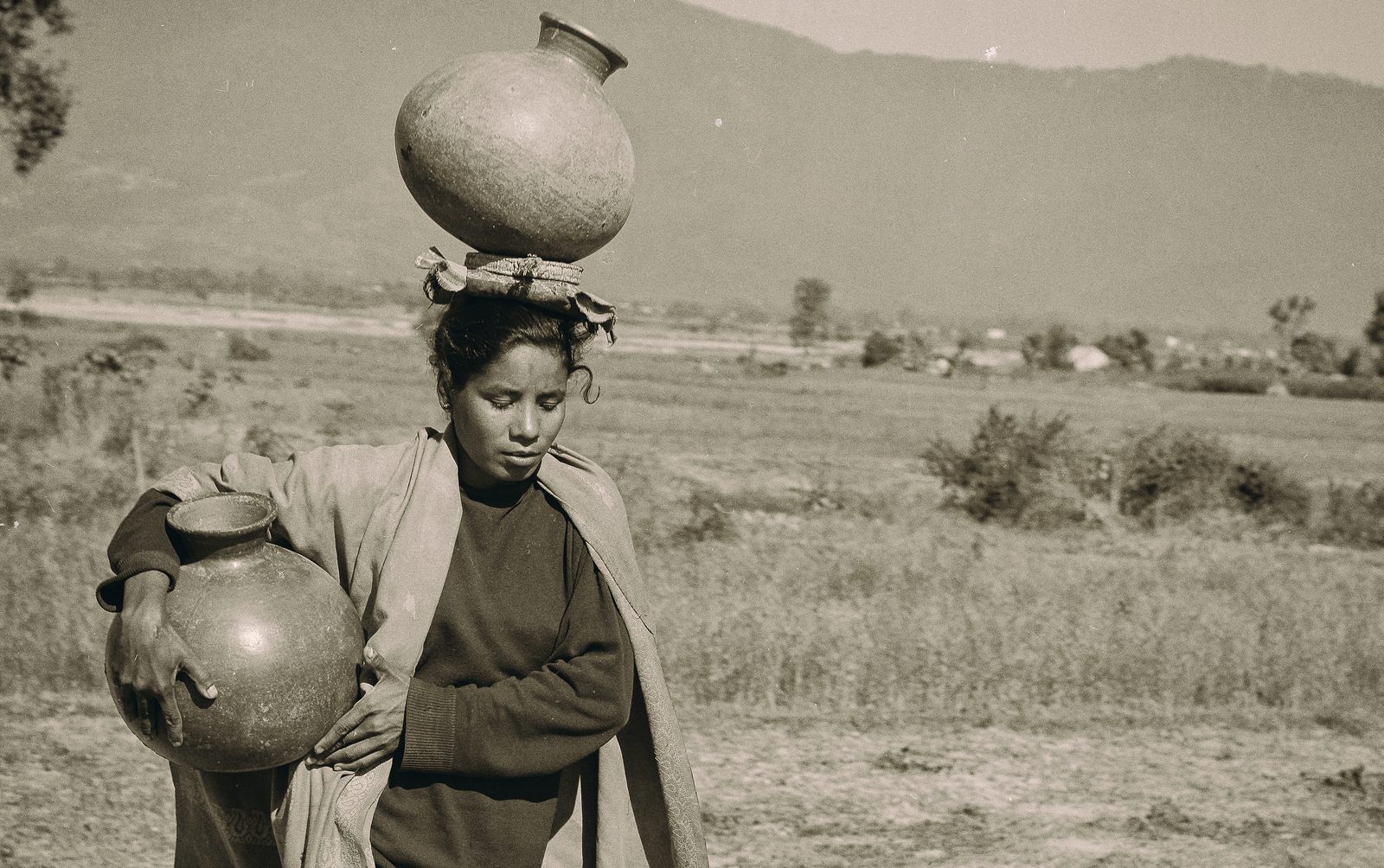 Documentary photograph of a woman carrying water